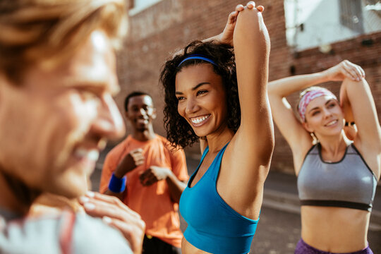 Diverse young group of people getting ready to jog and exercise together in the city