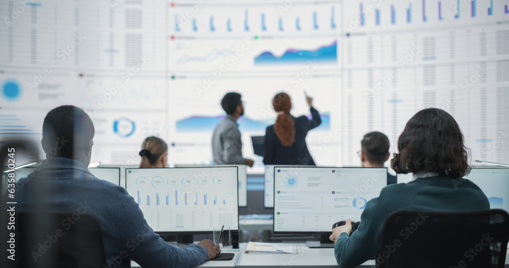 Fototapete Wide Zoom Out Back Shot Of Diverse Male And Female Risk Managers Analyzing Data On Digital Screen In Monitoring Room. Multiethnic Employees Working On Computers For Succesful Consulting Company