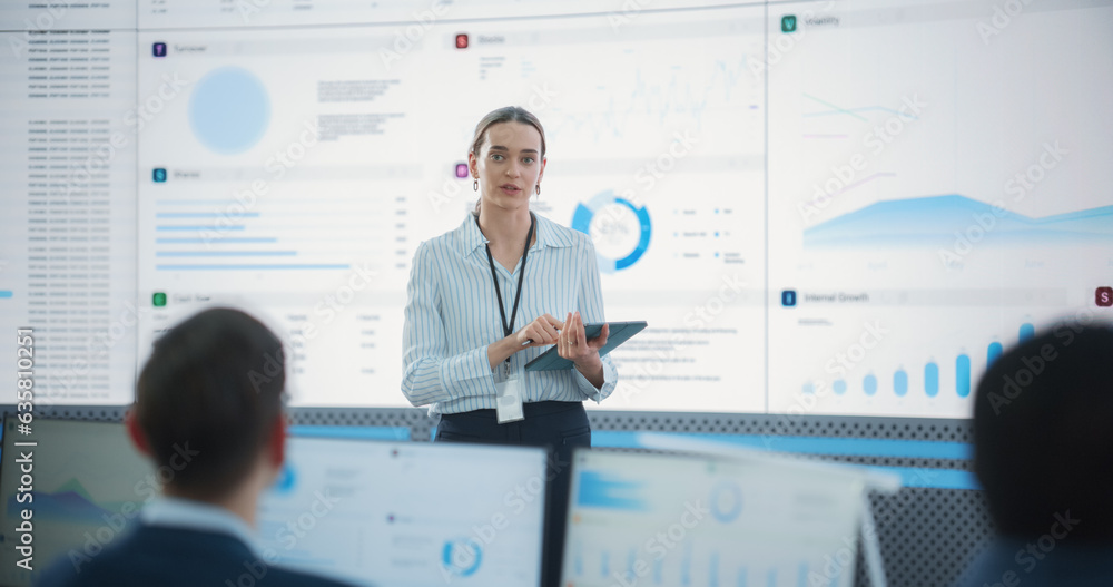 Aufkleber Female Project Manager With Tablet Computer Is Giving Presentation To Diverse Employees In Front of Big Digital Screen In Monitoring Room. Team Of Data Scientists Listening To New Objectives, Tasks.