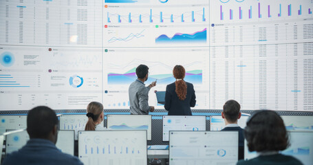 Wide Shot of Diverse Male And Female Data Analysts Discussing Graphs And Reports On Big Digital...
