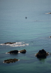 Sea lagoon with turquoise water and a figure on a boat in the distance