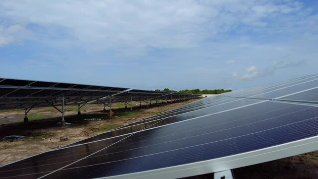 Established static shot of solar panel bifacial technology installed in photovoltaic farm in Africa with blue sunny sky