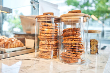 Oatmeal cookies on the marble kitchen table. Transparent glass jars with cookies in the interior of the cafe. Stylish interior of the kitchen of a trendy restaurant. decorative elements.