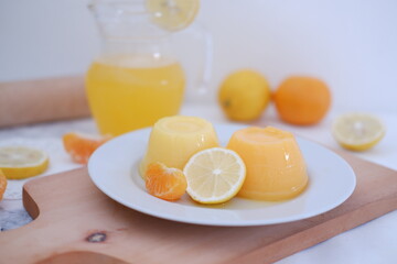 Orange jelly with fresh lemon and orange juice on a white background.