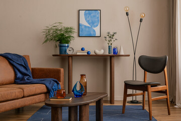 Aesthetic composition of living room interior with mock up poster frame, brown sofa, wooden...