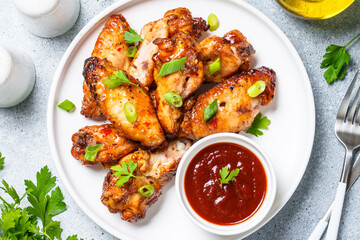 Grilled meat. Chicken wings in bbq sauce.. Top view on white stone table.