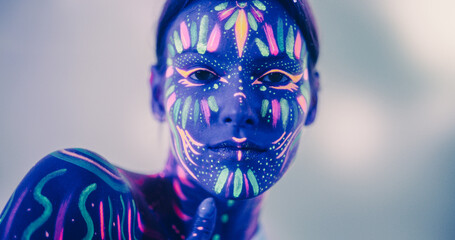 Young Sensual Model Poses with Grace and Poise, Her Vivid Body Paint Complementing Dark Abstract...