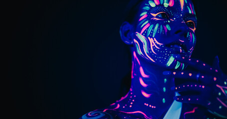 Beauty Close Up Photo: Young Female Poses with Confidence, Neon Paint Accentuating Her Facial Features Against an Low Key Studio Setting, Creating an Artistic Appearance