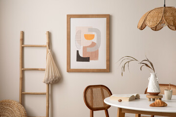 Interrior design of stylish dining room with round table, rattan chair, wooden commode, pock up poster and kitchen accessories. Beige wall with mock up poster. Home decor. Template.