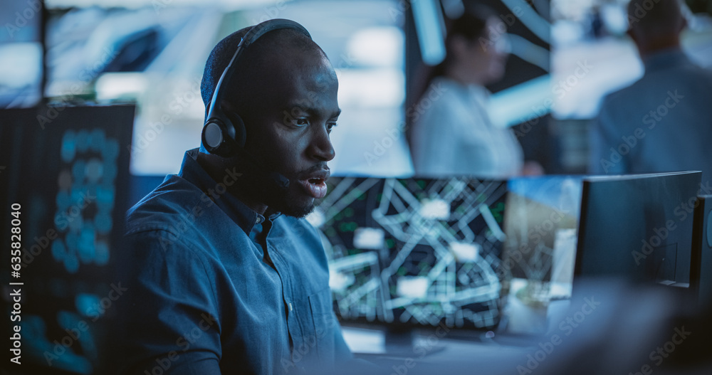 Poster Handsome Surveillance Specialist in a Modern Monitoring Room with Displays and Computers. Black Man Effectively Multitasking with Supporting Clients on a Phone Call and Computer Work