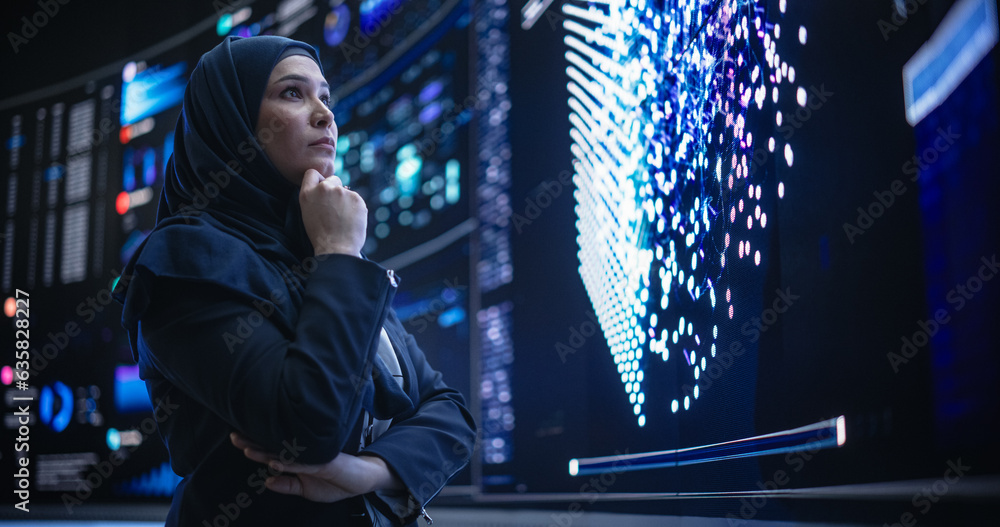 Leinwandbilder Portrait of a Smart Focused Middle Eastern Software Engineer Analyzing Neural Network Big Data on a Digital Screen. Young Arab Woman in Hijab Working in an Innovative Internet Service Company