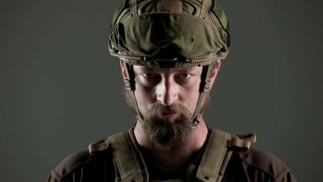 
A soldier in the army dressed in camouflage, studio shot. dark background. atmosphere. Ukrainian military