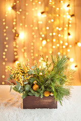 Floral arrangement in a wooden box with live spruce and ilex branches for decorating the house for the Christmas holidays.Christmas wooden box with fir branches for the holiday. new year celebration.