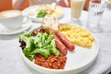 Simple American style Breakfast with sausages, scrambled eggs, baked beans, mushrooms and tomatoes. This dish is full of nutrients that you needed.