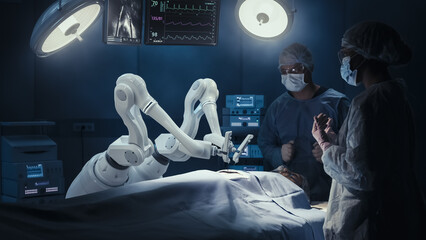 Two Surgeons Observing High-Precision Programmable Automated Robot Arms Operating Patient In...