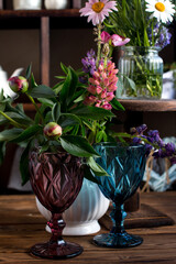 Beautiful multicolored glasses on a background of multicolored wildflowers. Village concept