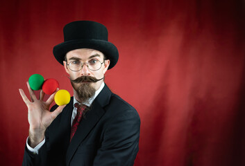 Vintage Caucasian Magician with top hat, glasses and mustache with colored balls