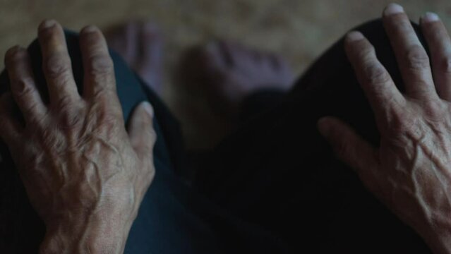 top view pensioner sits with his hands on his knees. concept of elderly people, loneliness, reflection, depression in old age. aging process