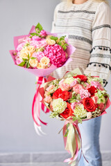 Two Small Beautiful bouquets of mixed flowers in woman hand. Floral shop concept . Beautiful fresh cut bouquet. Flowers delivery