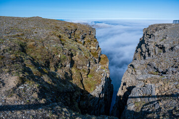 Rocky cliff and wonderful view of the clouds below
