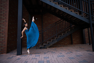 Beautiful Asian ballerina dancing outdoors. Urban landscape.