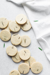 Top view of cut out rosemary sugar cookies, rosemary cookie on a white background, process of making rosemary sugar cookies