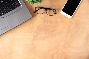 Laptop, glasses and phone - layout on a wooden table. Workspace for business, study.