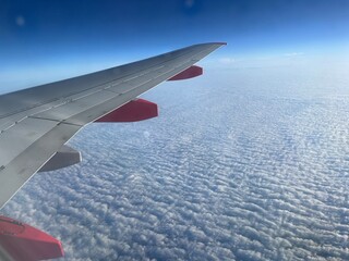 Obraz premium airplane wing over cirrus clouds