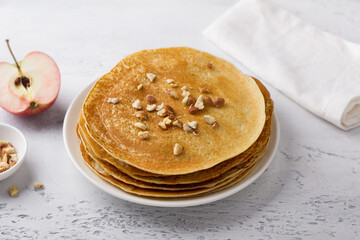 Apple pancakes with nuts on a light gray background, top view. Delicious homemade food