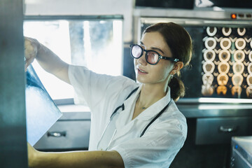 Fototapeta premium Female doctor check on scan results on monitors in laboratory
