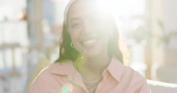 Laughing, face and a woman on a home sofa for a funny joke, meme or relax in summer with flare. Happy, portrait and a young excited girl or person in an apartment with confidence, humor and a smile