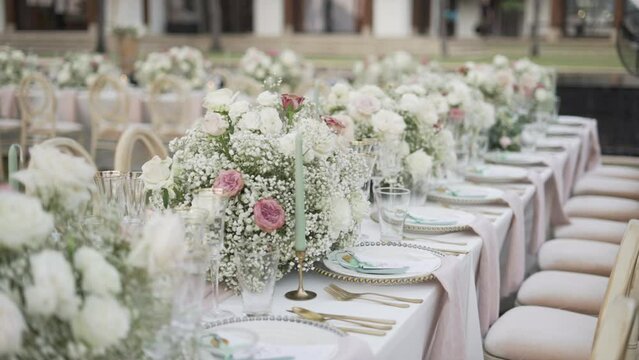 Event party reception decor outdoor. Wedding set up bouquet flowers candle tablecloth catering dinner.