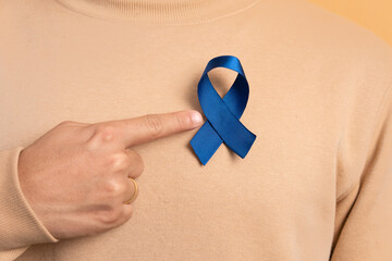 detail hands of brazilian man showing blue ribbon in studio shot. prostate cancer, awareness...