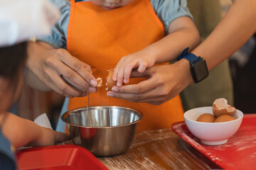 Asian girl learning to bake cake and cracking eggs cake Ingredients. Baking fun. This adorable baby...