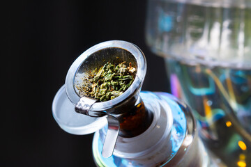 Macro close up smoking medical marijuana bud with bong