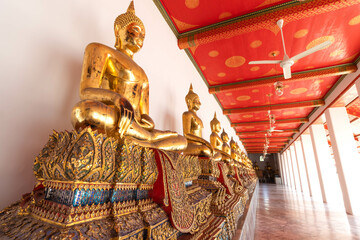 Golden Buddha statues at cloister of Wat Pho or temple of the reclining Buddha, Bangkok, Thailand