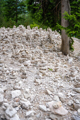 Small stone pyramides near alpine lake Braies or Pragser Wildsee, Dolomites Alps, Italy.