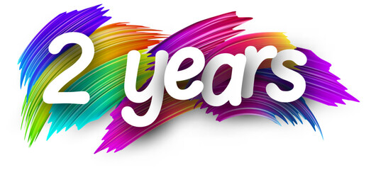 2 years paper word sign with colorful spectrum paint brush strokes over white. Vector illustration.