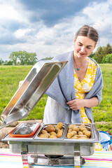 A woman prepares potatoes for a holiday dinner outside