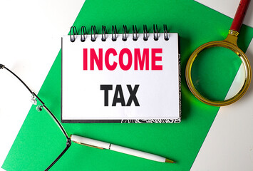 INCOME TAX text on notebook on green paper