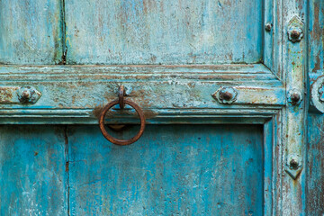 Antique Doorknob on the Aged and Rustic Blue Wooden Door