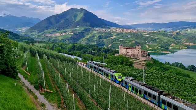 4K Cinematic View of Castel Cles and Santa Giustina Lake &mdash; Passenger Train Passing Through Famous Apple Orchards of Val di Non in Trentino Alps Italy