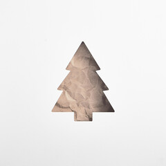 A square layout with a parchment Christmas tree stencil on a white backdrop, highlighting a...