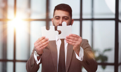 businessman show white jigsaw in hand, business strategy concept