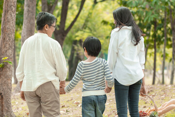 Happy Asian family spending time together outside in green nature and park, vacation of parents concept.