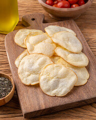 Smoked provolone cheese chips in a bowl with cherry tomatoes and oregano over wooden table