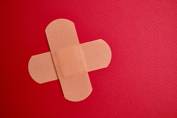 Medical plaster on a red background. Blood donation, space for text. Health and medicine concept