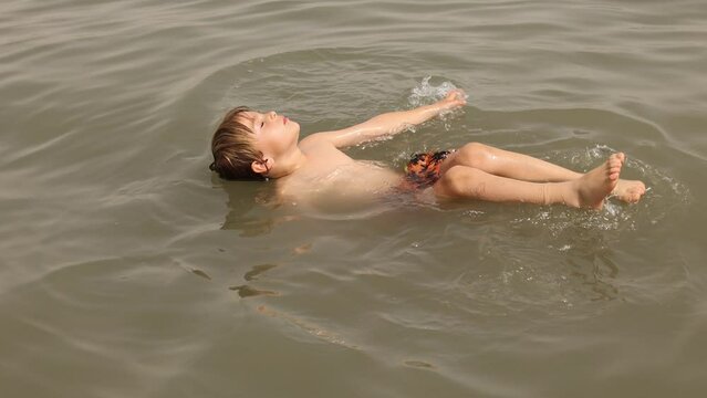 Child, boy, floating in the Dead sea on a very hot summer day