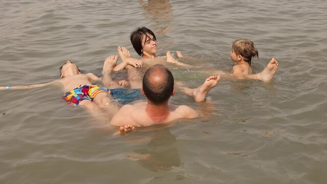 Child, boy, floating in the Dead sea on a very hot summer day