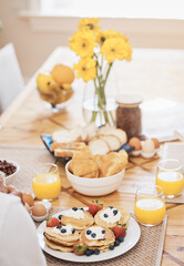 Fototapeta na wymiar Pancakes, breakfast and orange juice on table in home in the morning. Bread waffle, hands and fruits for eating, healthy diet and strawberry cream in wellness nutrition, blueberry food and egg meal.